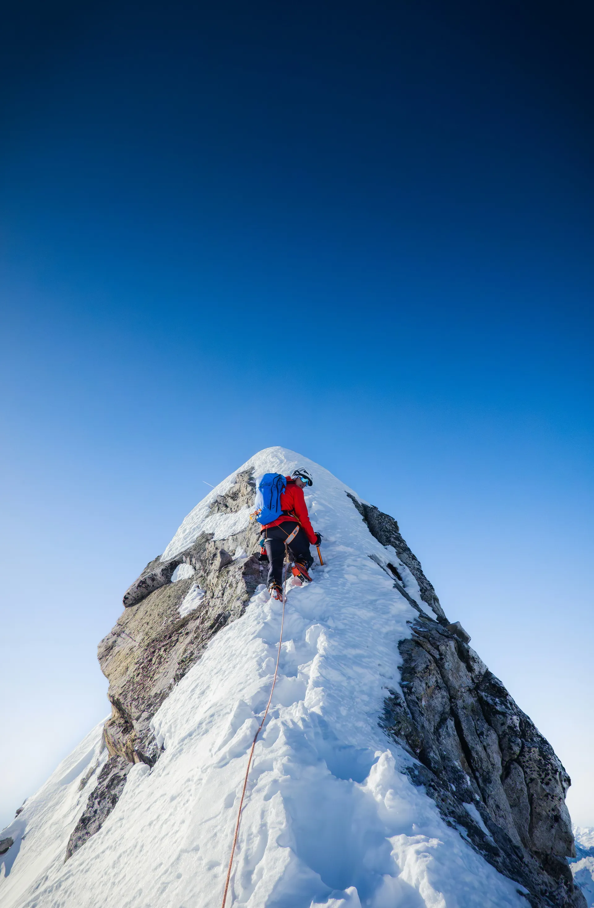 Mountaineer climbing a snowy ridge